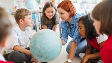 A group of small school kids with teacher learning geography.